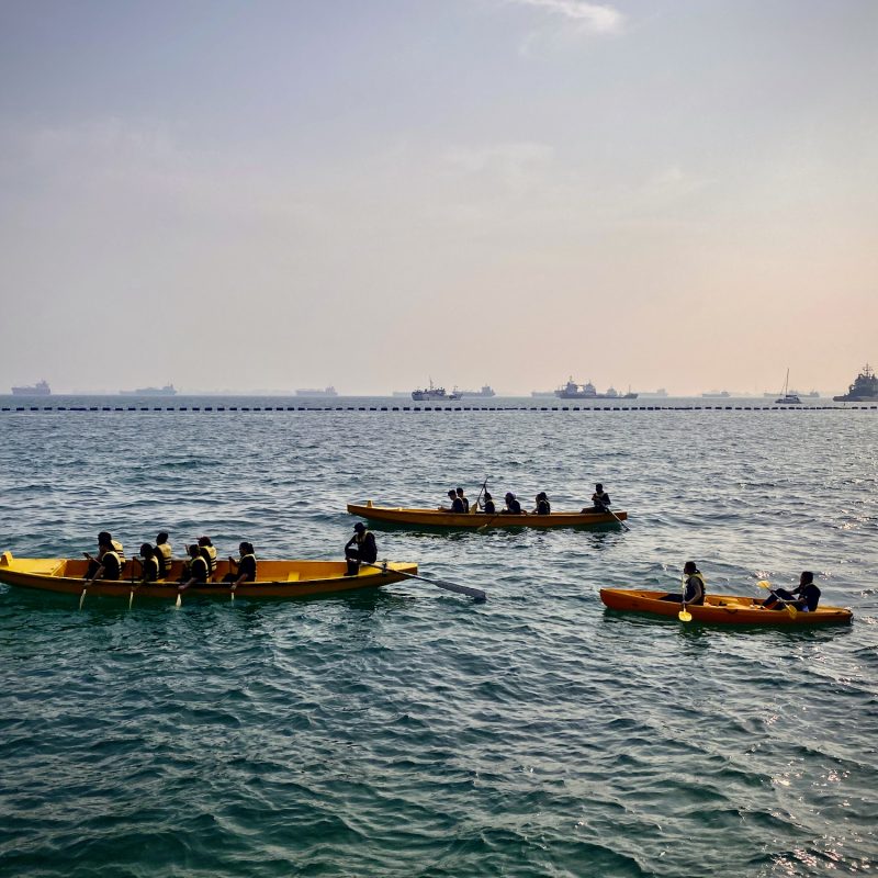 Rowers Amidst Moored Boats